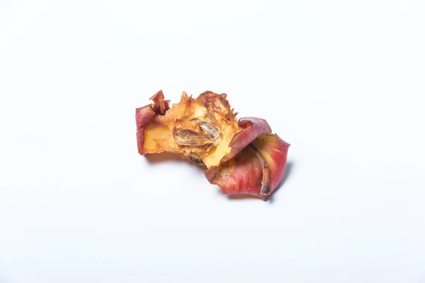 Not a fresh Apple core. Leftovers from a bitten Apple. A darkened Apple stub on a white background.