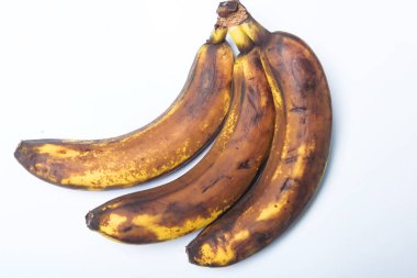 Kararmış muz kabuğu. Beyaz arka planda bir grup olgunlaşmış muz. Meyve ve muzun uygunsuz depolanması