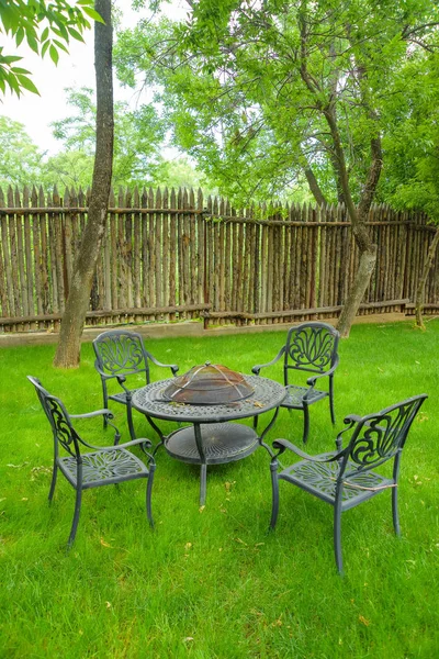 Garden furniture with built-in barbecue hearth fireplace in the table. Recreation area with a barbecue hearth. Metal garden chairs and table. Garden table with fireplace