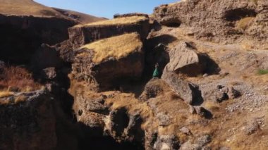 Güney Kazakistan hava manzaralı Aksu Kanyonu 'nda yeşil elbiseli bir kadın. Peri masalı gibi bir gece elbisesi giymiş genç bir kadın. Dağlarda uzun elbiseli güzel bir kız.