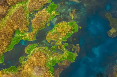 Sonbaharın sonlarında Kazakistan 'ın güneyindeki Balykty Gölü, hava manzaralı. Derin mavi suyu olan güzel küçük bir göl. Nehir yukarıdan göl manzarasına akar. Bozkırdaki göl