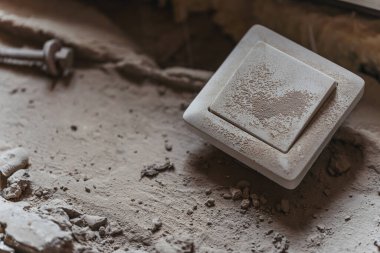 İnşaat alanında elektrik düğmesi. Tozlu beyaz plastik elektrik düğmesi. Evdeki elektrik ve inşaat tesisatını tamir ediyor.