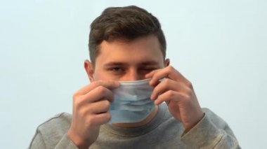 Bir adam koruyucu maske takıyor. Koronavirüs salgını başladı. Karantina salgını ve kendini izole etme. Tıbbi maskeli bir adam. Koruyucu tıbbi yüz maskesi. Covid 19 Salgın Virüs Koruma Programı.
