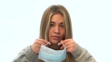 Neşeli mutlu kadın koruyucu maskeyi çıkarıyor. Coronavirus salgını sona erdi. Salgının sonu geldi. Güzel genç kız tıbbi maskeyi çıkarıyor. Karantina ve kendini izole etmenin sonu.