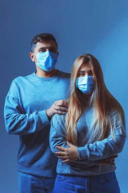 Tıbbi maskeli bir adam ve kadın. Bir salgın sırasında aile portresi. Koruyucu tıbbi yüz maskesi. Covid 19 Salgın Virüs Koruma Programı.