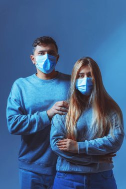 Tıbbi maskeli bir adam ve kadın. Bir salgın sırasında aile portresi. Koruyucu tıbbi yüz maskesi. Covid 19 Salgın Virüs Koruma Programı.