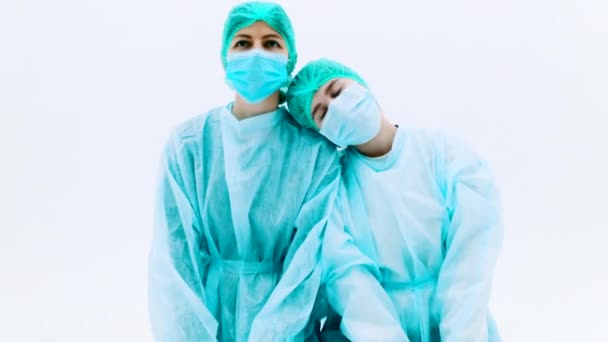 Twee Vrouwen Beschermende Medische Pakken Gezichtsmaskers Jonge Meisjes Knielen Een — Stockvideo