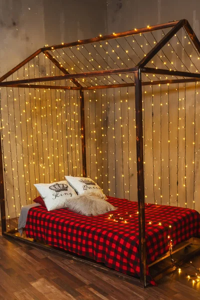 ガーランド付きの家の形でベッド 部屋の黄色の暖かいガーランドクリスマスの装飾 寝室の装飾 — ストック写真