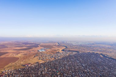 Şymkent hava manzaralı Kainar Bulak yerleşim bölgesi. Güney Kazakistan 'daki Aksu Kanyonu' nun sonu. Özel ev inşaatı. Bir şehrin ya da köyün üst görüntüsü. Şymkent şehrinin evleri ve sokakları insansız hava araçlarıyla dolu.
