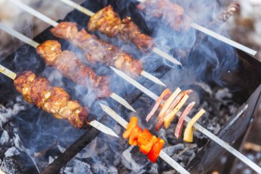 Alışılmadık bir şiş şiş kebap ile kamp yapmak sosis peynirli şiş kebap. Izgaraya bir şiş ve kızarmış patates koy. Kış pikniğinde dumanın içinde barbekü.