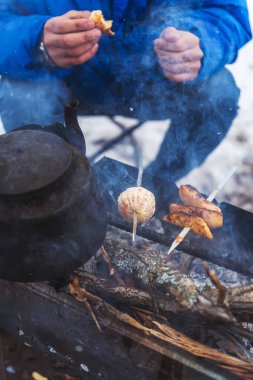 Sıradışı turuncu şiş kebabıyla ızgara yapmak. Mandalina portakallı bir şiş ve ızgaraya kızarmış patates şişi koy. Kış pikniğinde dumanın içinde barbekü.