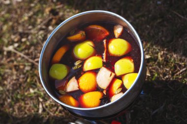 Doğada kamp yaparken sıcak şarap pişirmek. Turist gazlı ocağında sıcak şarap pişirmek gibi. Elmalı ev yapımı şarap.