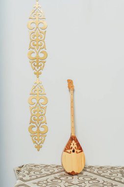 Kazakh national musical instrument dombra on a white background. National Kazakh decor gold ornaments and household items. Kazakh Kyrgyz ethnic background clipart
