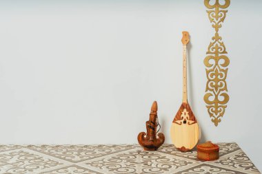 Beyaz arka planda Kazak ulusal müzik aleti dombra. Ulusal Kazak dekor altın süslemeleri ve ev eşyaları. Kazak Kırgız etnik geçmişi