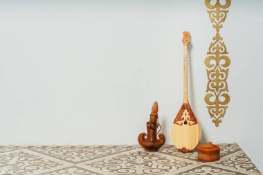 Kazakh national musical instrument dombra on a white background. National Kazakh decor gold ornaments and household items. Kazakh Kyrgyz ethnic background clipart