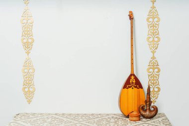Beyaz arka planda Kazak ulusal müzik aleti dombra. Ulusal Kazak dekor altın süslemeleri ve ev eşyaları. Kazak Kırgız etnik geçmişi