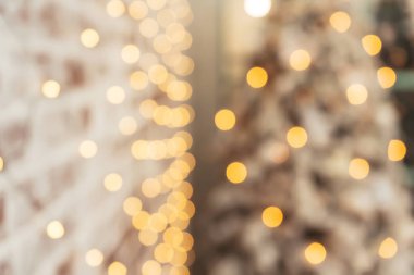 Bokeh çelenkleri ve karla kaplı beyaz bir Noel ağacı. Arka plan deseni Noel süsleri, sıcak ampuller, çelenkler. Güzel ışık Noel arkaplanı