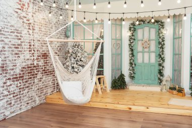 Noel verandasının arka planında hasır salıncak var. Noel terasında hamakta salıncak ördüm. Yeni yıl için fotoğraf stüdyosundaki ev dekorasyonları.