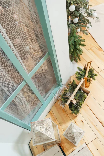 Christmas decor on the wooden porch, the view from the top. Metal white lanterns candlesticks and wooden boxes with fir branches. Wooden terrace with Christmas decor