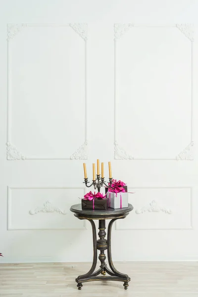 Golden Candles Candelabrum Black Table Gifts Boxes Background White Wall — Stock Photo, Image