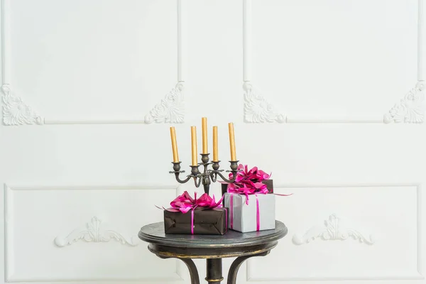 Golden Candles Candelabrum Black Table Gifts Boxes Background White Wall — Stock Photo, Image