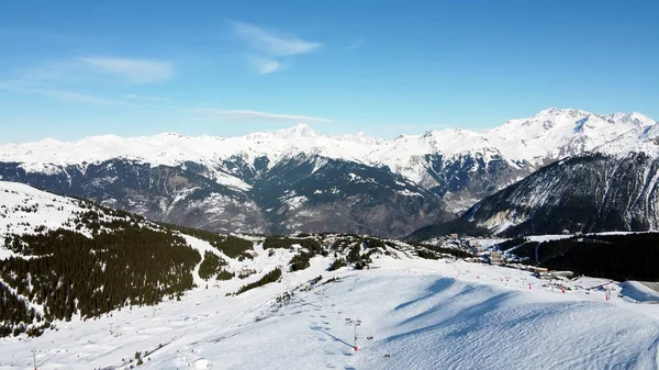 Vista aérea das montanhas dos Alpes em França. Montanhas cobertas de neve. Instalações de esqui alpino de cima . — Fotografia de Stock