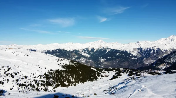 Vista aérea das montanhas dos Alpes em França. Montanhas cobertas de neve. Instalações de esqui alpino de cima . — Fotografia de Stock