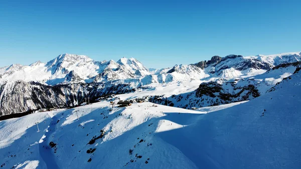 Aerial view of the Alps mountains in France. Mountain tops covered in snow. Alpine ski facilities from above. — Stock Photo, Image