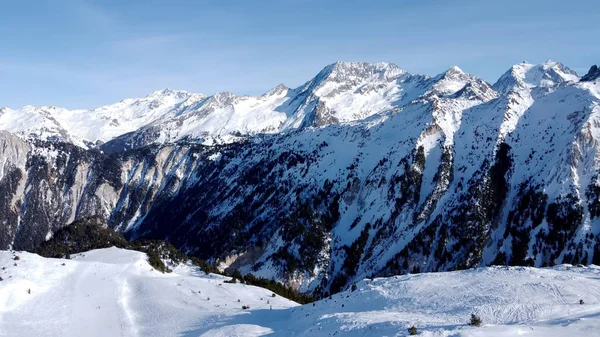 Aerial view of the Alps mountains in France. Mountain tops covered in snow. Alpine ski facilities from above.