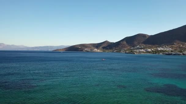 Vue aérienne d'un bateau à moteur en excès de vitesse dans une mer de couleur bleu profond. Île de Spinalonga, Crète, Grèce 