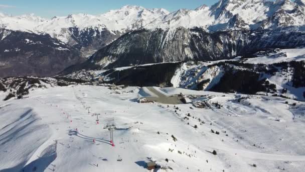 Luchtfoto van de Alpen in Frankrijk. Bergtoppen bedekt met sneeuw. Alpine ski faciliteiten van bovenaf. — Stockvideo