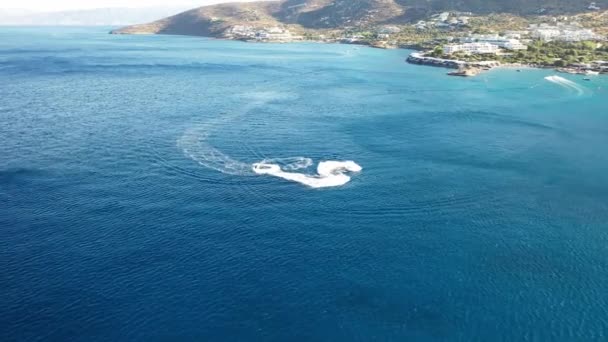 Flygfoto över en jet ski båt i ett djupt blått hav. Spinalonga Island, Kreta, Grekland — Stockvideo