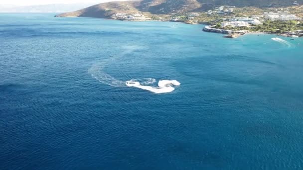 Koyu mavi bir denizde bir jet ski teknesinin hava görüntüsü. Spinalonga Adası, Girit, Yunanistan — Stok video