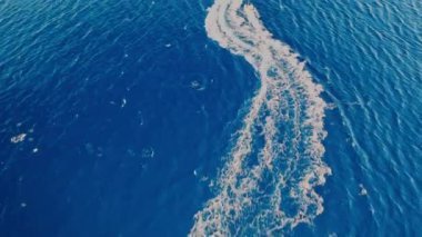 Motorlu bir teknenin tüpü çektiği hava görüntüsü. Elounda, Girit, Yunanistan