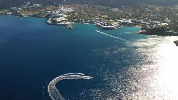 Vista aérea de um barco a motor rebocando um tubo. Elounda, Creta, Grécia — Vídeo de Stock