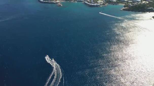 Vista aérea de um barco a motor rebocando um tubo. Elounda, Creta, Grécia — Vídeo de Stock