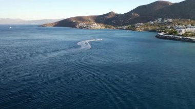 Bir su kayakçısını çeken motorlu teknenin hava görüntüsü. Elounda, Girit, Yunanistan
