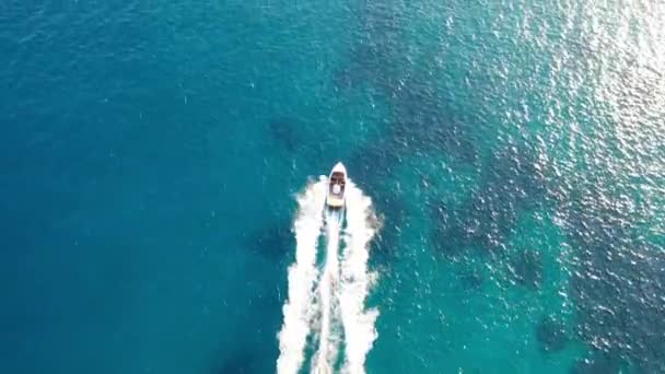 Vista aérea de una lancha a motor remolcando a un esquiador acuático. Elounda, Creta, Grecia — Vídeos de Stock