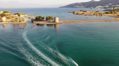 Koyu mavi bir denizde, motorlu bir teknenin havadan görünüşü. Kolokitha Adası, Girit, Yunanistan