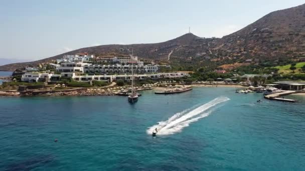 Vista aérea de um barco de esqui a jato em um mar de cor azul profundo. Spinalonga Island, Creta, Grécia — Vídeo de Stock