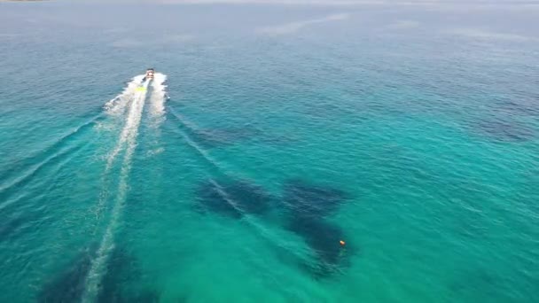 チューブを牽引するモータボートの空中ビュー。ギリシャクレタ島エルンダ — ストック動画