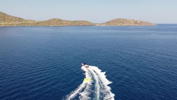 Vue aérienne d'un bateau à moteur remorquant un tube. Elounda, Crète, Grèce 