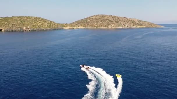 Vue aérienne d'un bateau à moteur remorquant un tube. Elounda, Crète, Grèce 