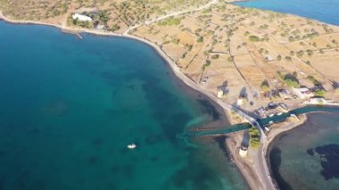Koyu mavi bir denizde, motorlu bir teknenin havadan görünüşü. Kolokitha Adası, Girit, Yunanistan