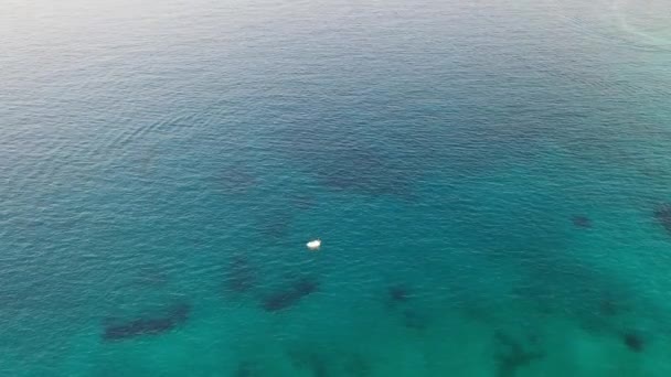 Vista aérea de una lancha motora en un mar de color azul profundo. Isla Kolokitha, Creta, Grecia — Vídeos de Stock