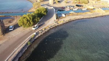 Koyu mavi bir denizde, motorlu bir teknenin havadan görünüşü. Kolokitha Adası, Girit, Yunanistan