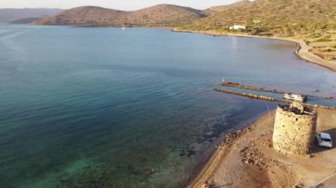 Koyu mavi bir denizde, motorlu bir teknenin havadan görünüşü. Kolokitha Adası, Girit, Yunanistan