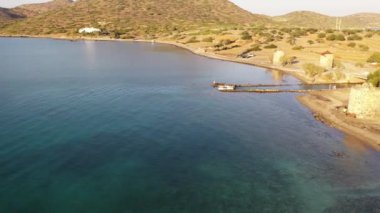Koyu mavi bir denizde, motorlu bir teknenin havadan görünüşü. Kolokitha Adası, Girit, Yunanistan