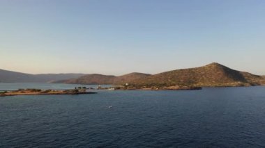Koyu mavi bir denizde, motorlu bir teknenin havadan görünüşü. Kolokitha Adası, Girit, Yunanistan