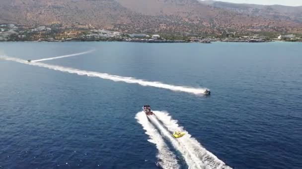 Повітряний вид моторного човна буксирує трубку. Елунда, Крит, Греція — стокове відео